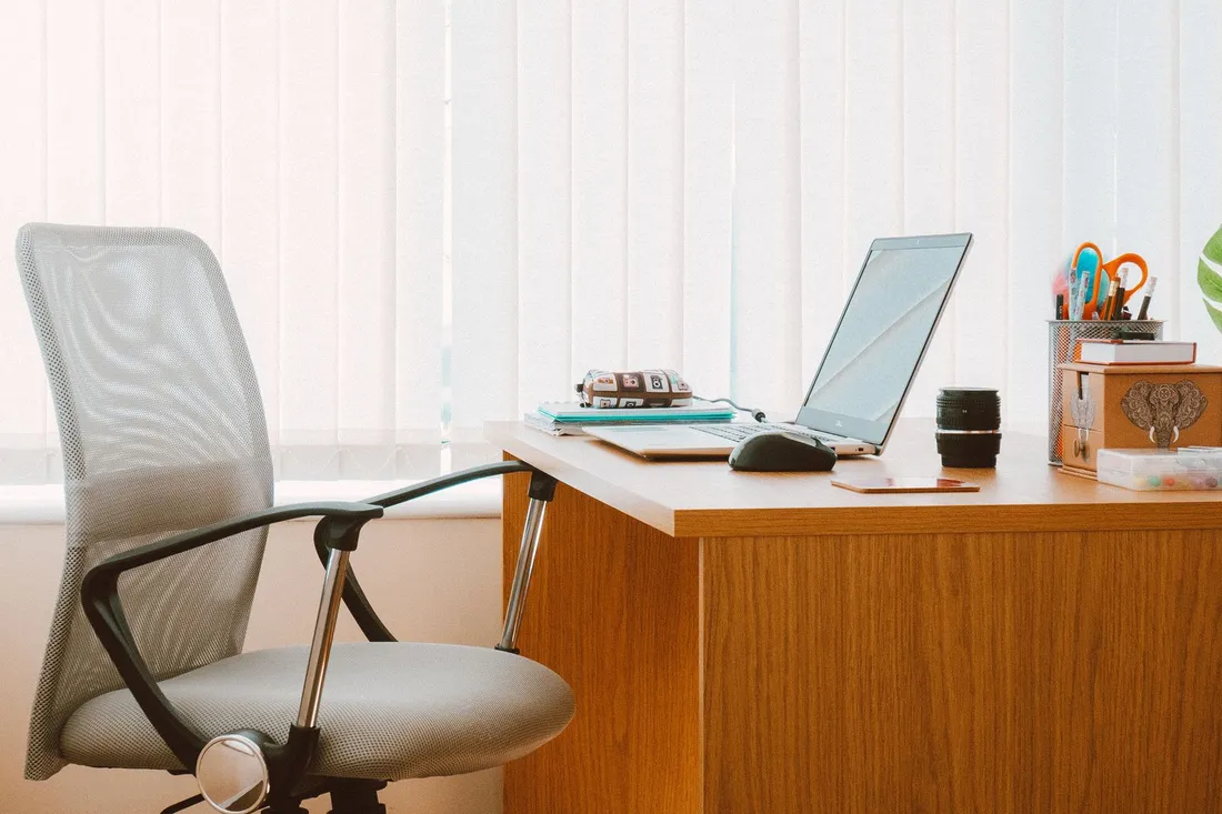A bright, modern small-agency office with a desk, chair and window